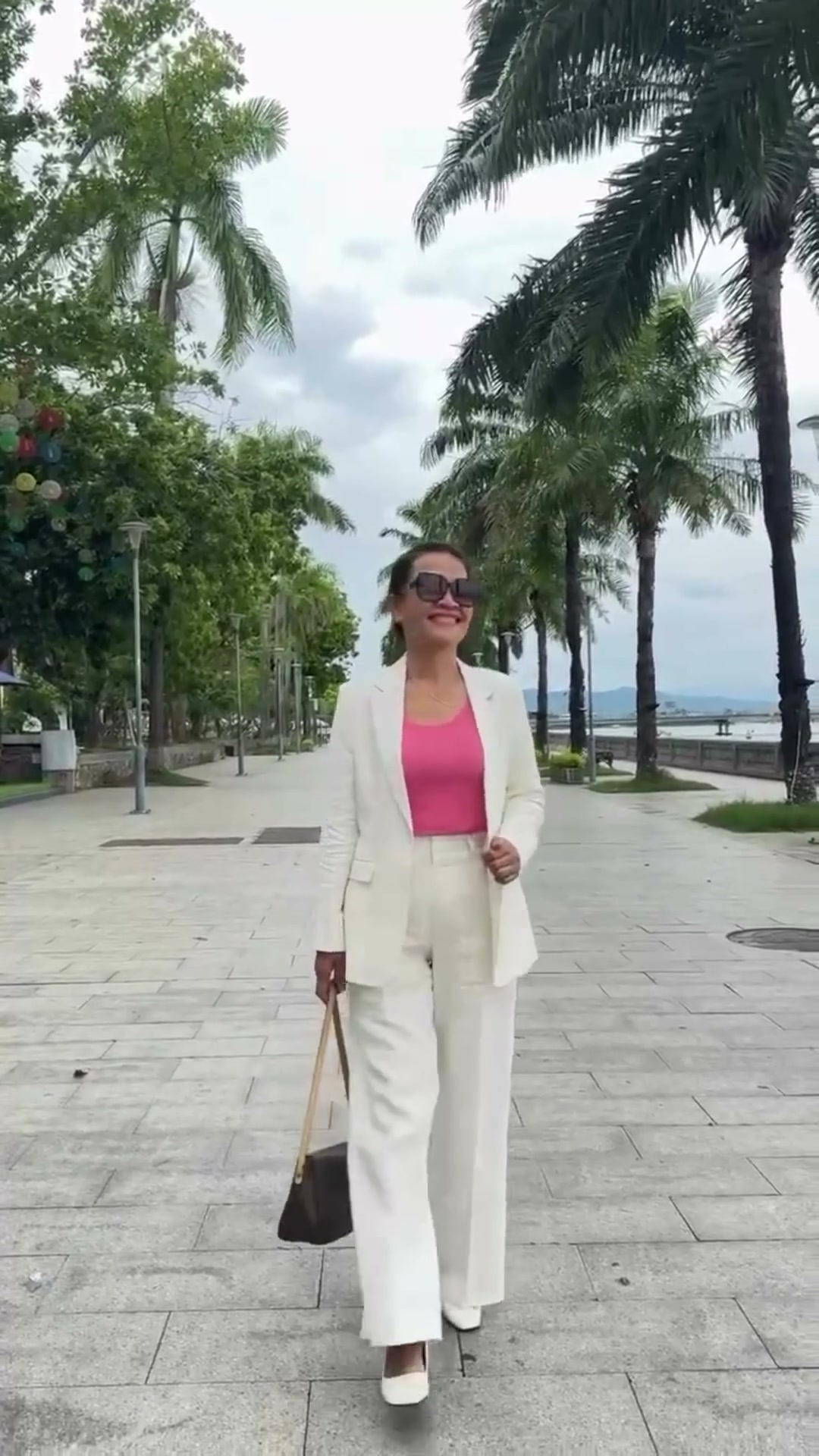 Client wearing a white women's tailored suit outdoors | Khách hàng mặc suit nữ trắng may đo ngoài trời