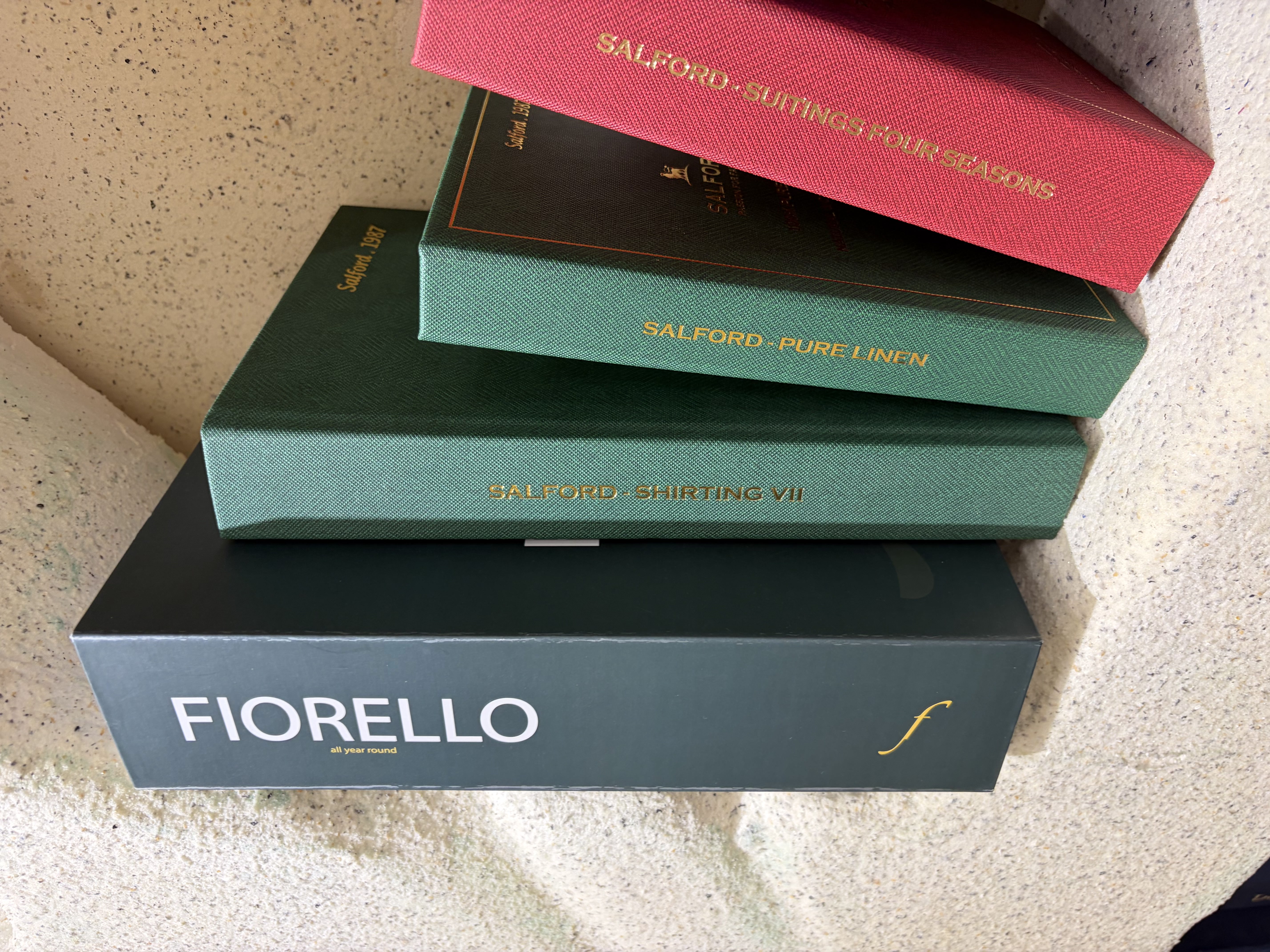 Stacked suiting fabric books from Italian mills | Chồng sổ vải suit từ các nhà dệt Ý