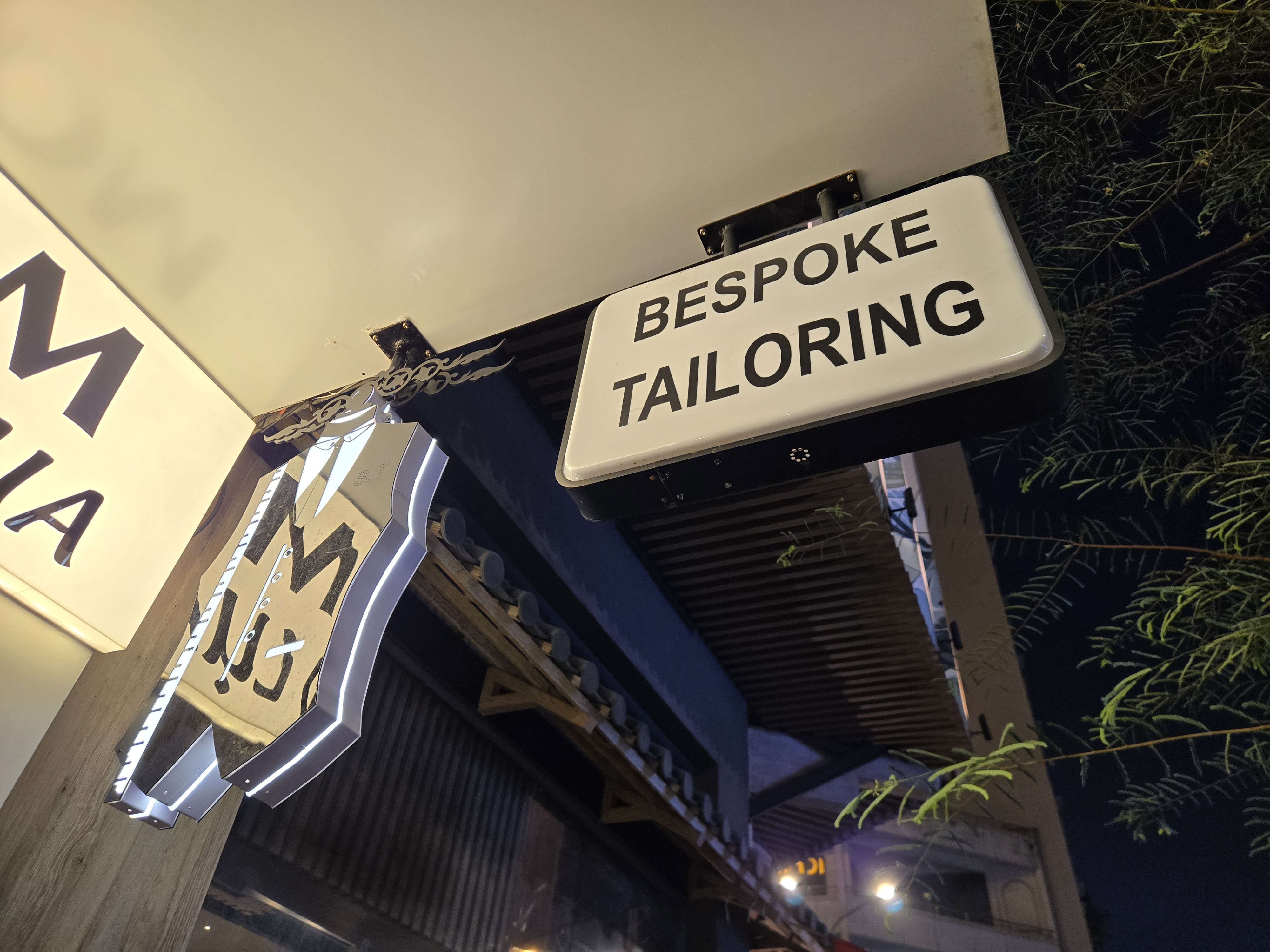 Bespoke tailoring sign outside S.T Tailor at night | Biển hiệu may đo riêng của S.T Tailor về đêm