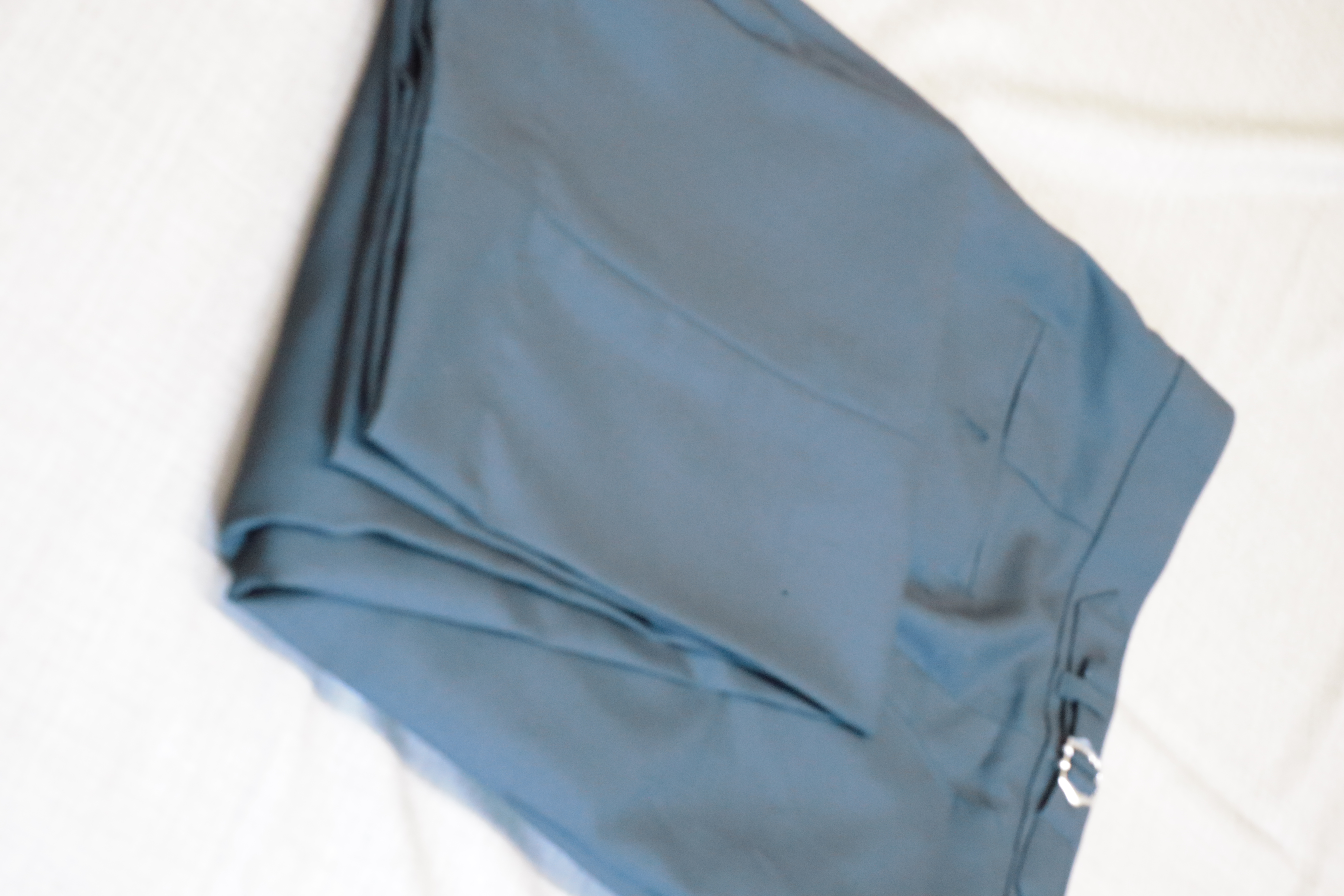 Light blue tailored trousers folded on white cloth | Quần xanh nhạt may đo gấp trên nền trắng