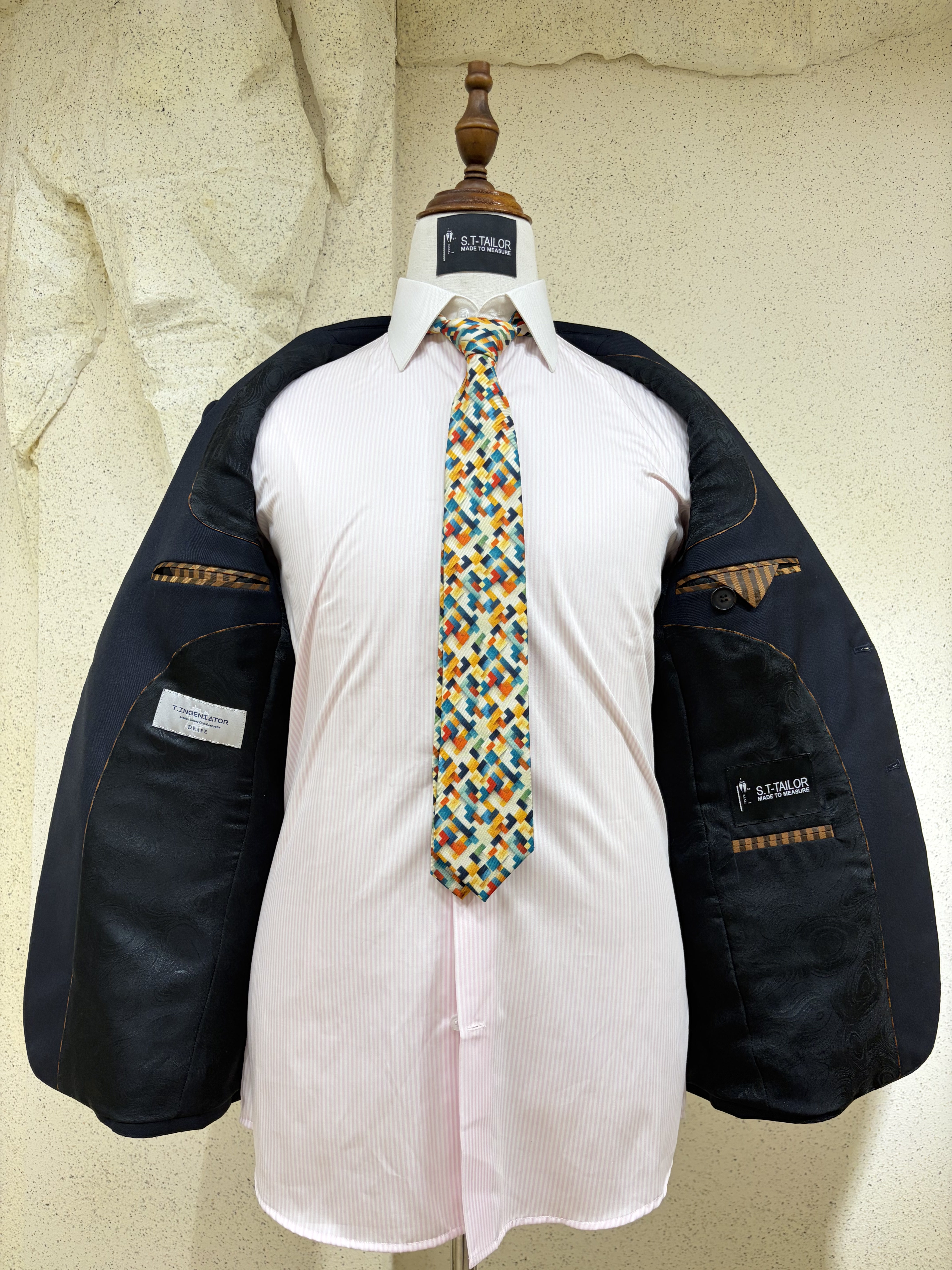 Open tailored jacket showing patterned lining and inner labels | Áo khoác may đo mở thân, thể hiện lớp lót hoa văn và nhãn bên trong