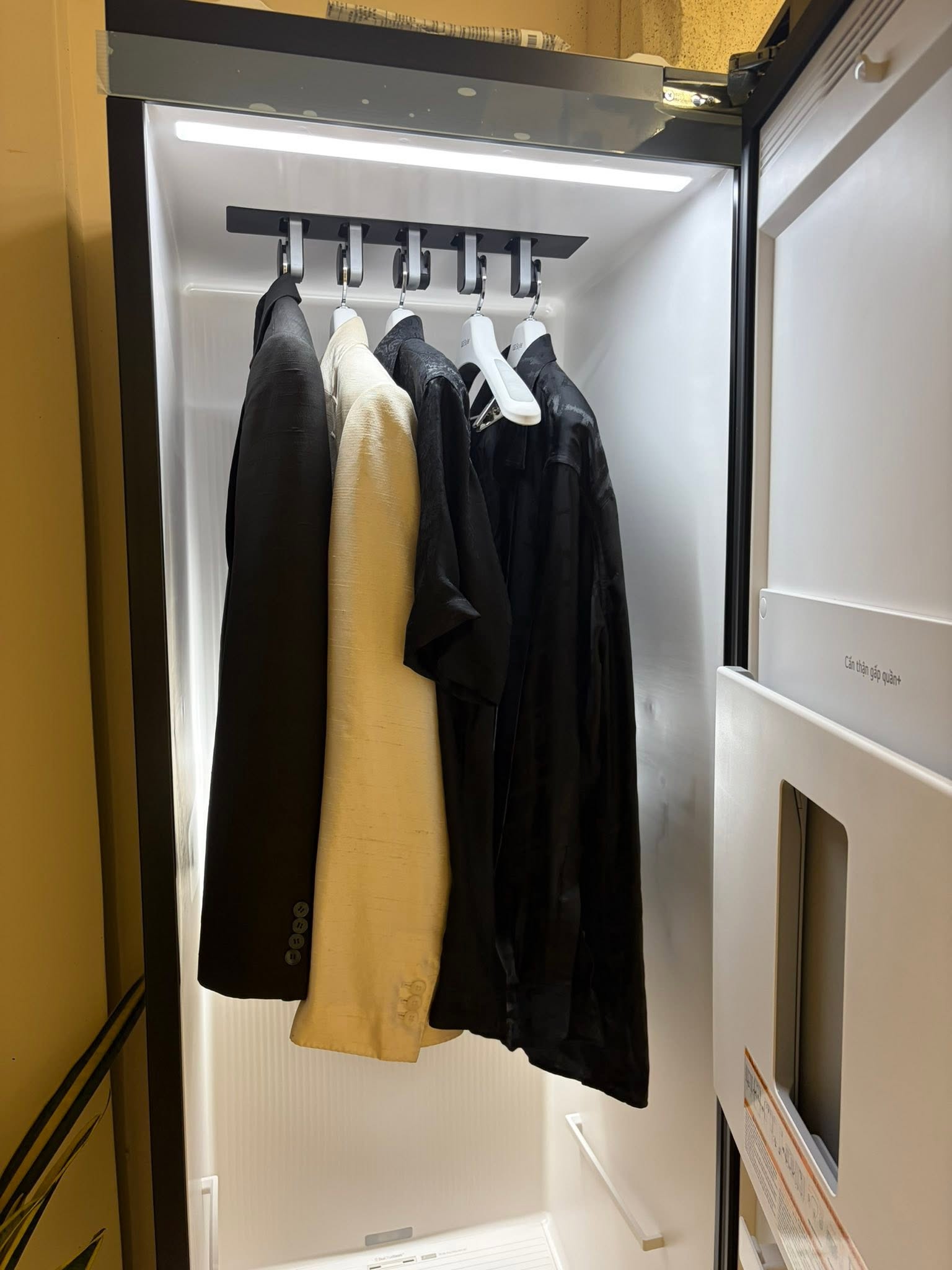 Tailored garments on a showroom wardrobe rail | Trang phục may đo trên giá treo tại showroom